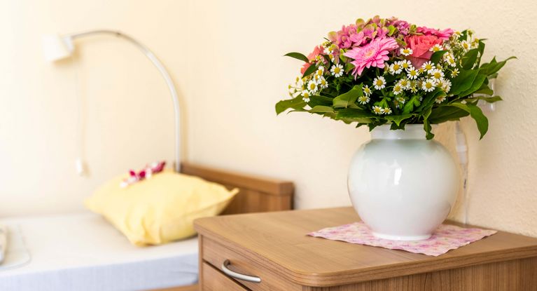 Blumenstraße auf dem Nachttisch in einer Vase neben dem Bett in der Seniorenresidenz